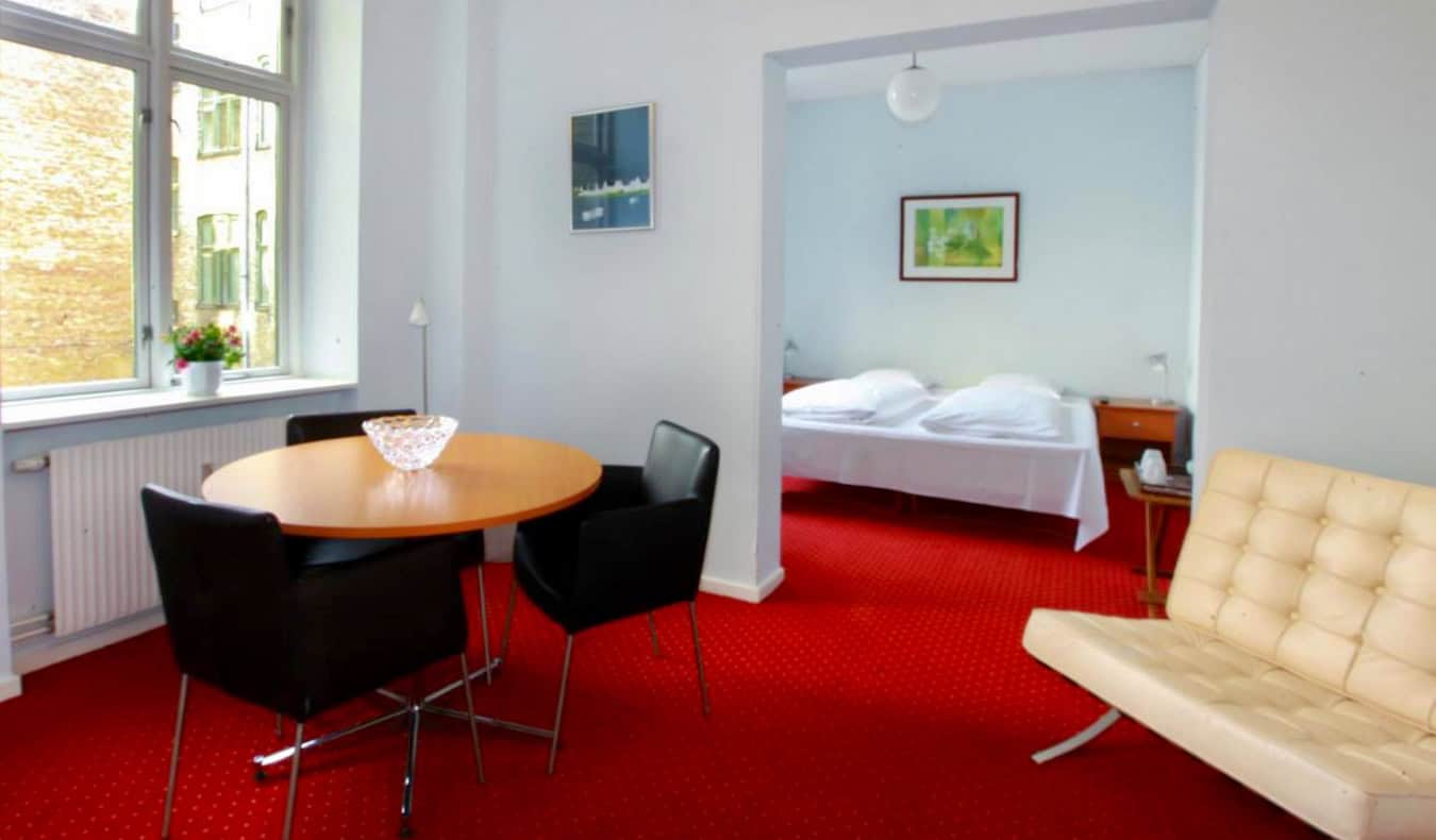 A airy and spacious hotel room with bright red carpet at Hotel Nora in Copenhagen, Denmark