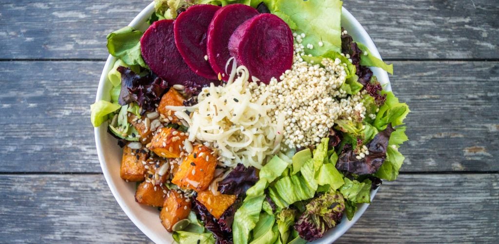 raw vegan salad with carrots, beets, lettuce and grains