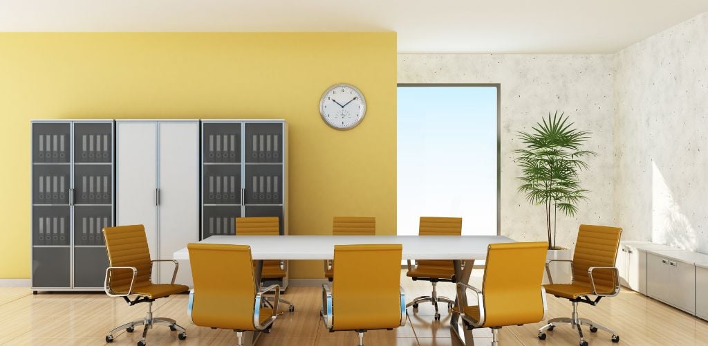 meeting room with yellow wall paint and clock on wall